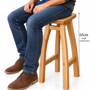 Mannaz 65cm solid oak counter stool with curved legs and footrests, shown with a person seated to demonstrate height and scale.
