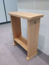 Narrow solid oak side table positioned beside a sofa