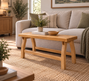 Uruz handmade solid white oak bench positioned in front of a sofa in a modern living room